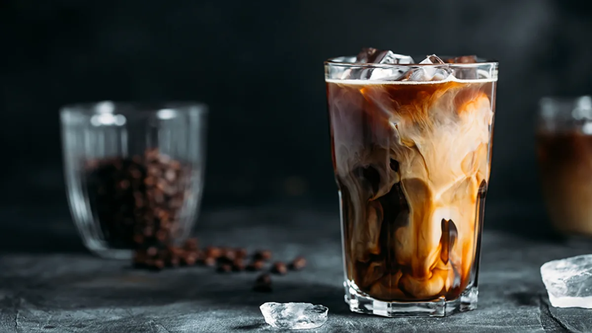 Vaso de cold brew con hielo sobre una mesa oscura